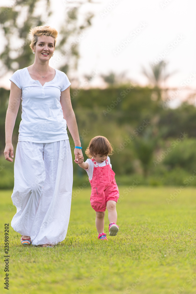 Fototapeta premium mother and little daughter playing at backyard