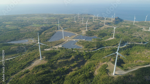 Aerial view of Windmills for electric power production on the seashore. Bangui Windmills in Ilocos Norte, Philippines. Solar farm, Solar power station. Ecological landscape: Windmills, sea, mountains
