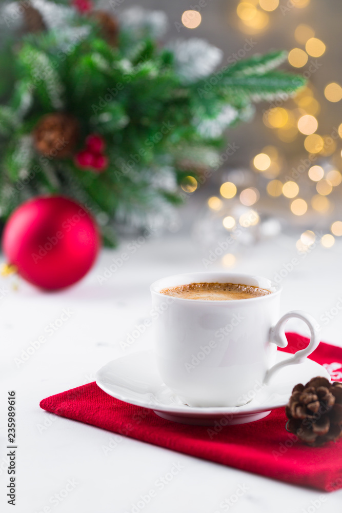 Cup of espresso or americano coffee in white cup in cozy Christmas arrangement, festive decoration with bokeh background, copy space Cup of espresso or americano coffee in white cup in cozy Christmas arrangement, festive decoration with bokeh background, copy space