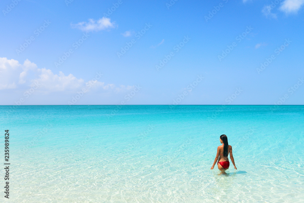 Beach luxury travel getaway resort bikini woman swimming in idyllic turquoise ocean water in paradise destination. Beach luxury travel getaway resort bikini woman swimming in idyllic turquoise ocean water in paradise destination.
