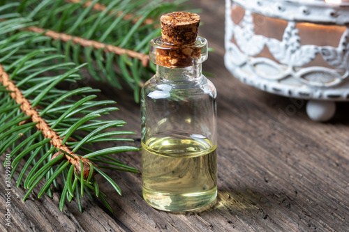 Fototapeta Naklejka Na Ścianę i Meble -  A bottle of spruce essential oil with fresh spruce branches