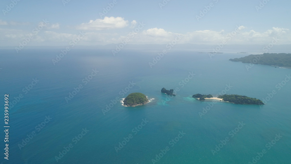 Aerial view islands with sand beach Lahus and turquoise water in blue lagoon among coral reefs, Caramoan Islands, Philippines. Landscape with sea, tropical beach.