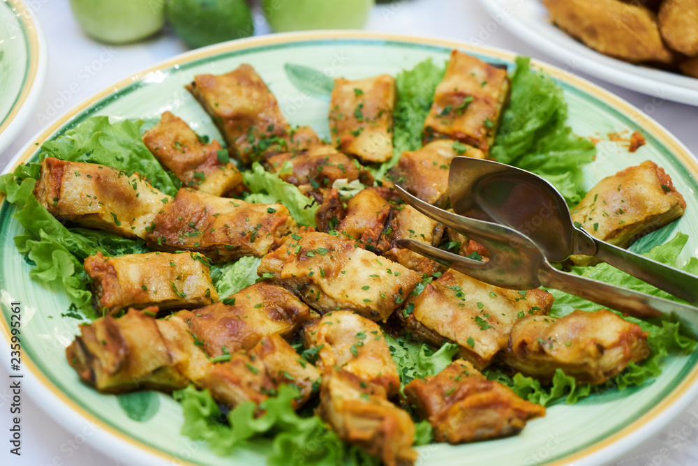 Minced beef stuffed crepes served with fresh salad leaves on a w Minced beef stuffed crepes served with fresh salad leaves on a w