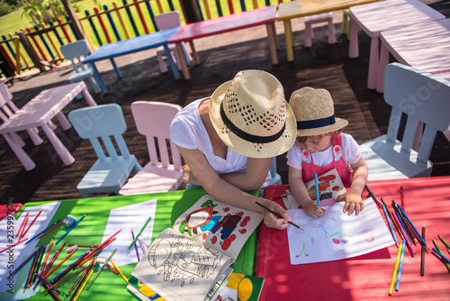 mom and little daughter drawing a colorful pictures