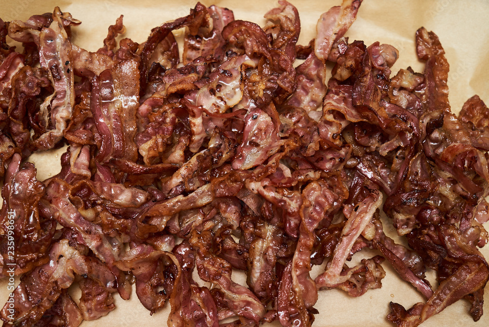 Hot fried bacon pieces background, close-up. Freshly