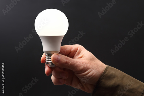 Canvastavla human hand holding the included led lamp on a dark background