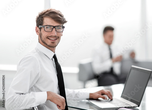 Businessman sitting at office desk working on laptop computer