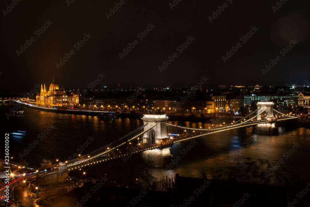 Budapest, Ungarn., Kettenbrücke über die Donau, im Hintergrund das monumentale Parlamentsgebäude bei Nacht mit Beleuchtung neben der Donau