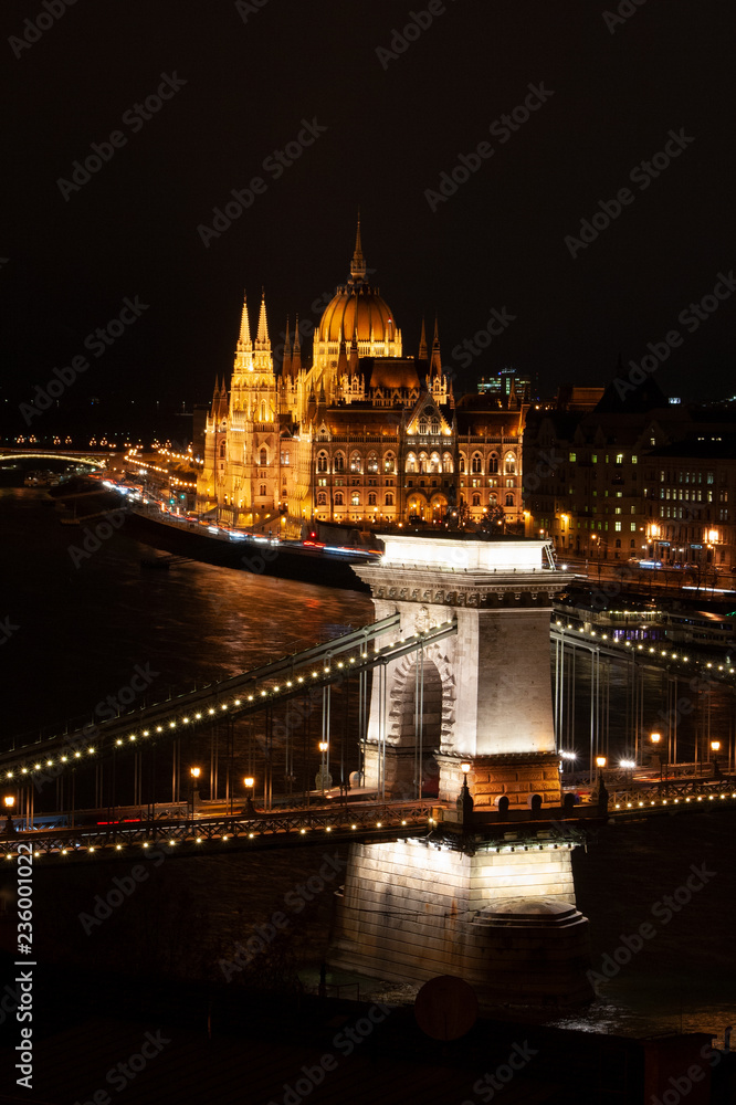 Budapest, Ungarn., Kettenbrücke über die Donau, im Hintergrund das monumentale Parlamentsgebäude bei Nacht mit Beleuchtung neben der Donau