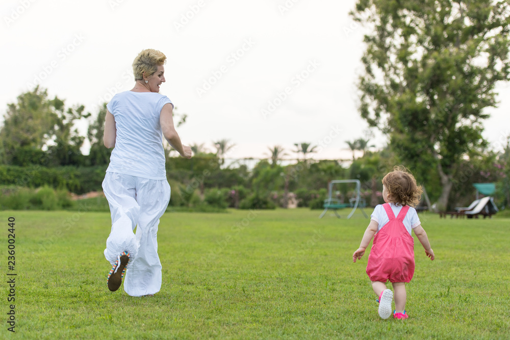 mother and little daughter playing at backyard mother and little daughter playing at backyard