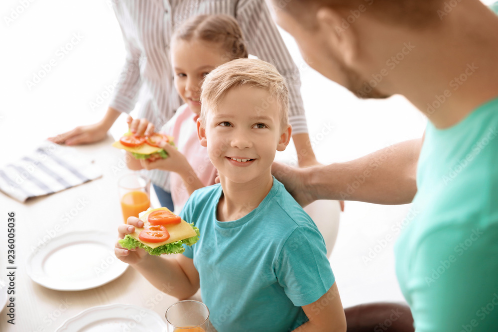 Little boy holding tasty toast with vegetables and cheese indoors Little boy holding tasty toast with vegetables and cheese indoors