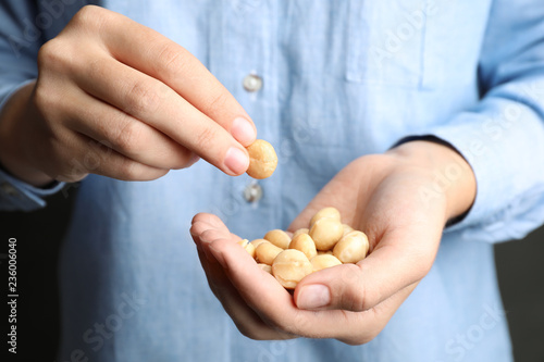 Woman holding shelled organic Macadamia nuts, closeup