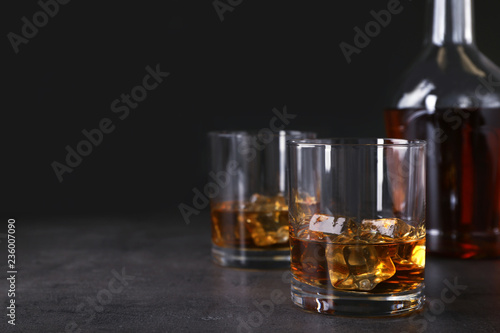 Fototapeta Naklejka Na Ścianę i Meble -  Golden whiskey in glass with ice cubes on table. Space for text