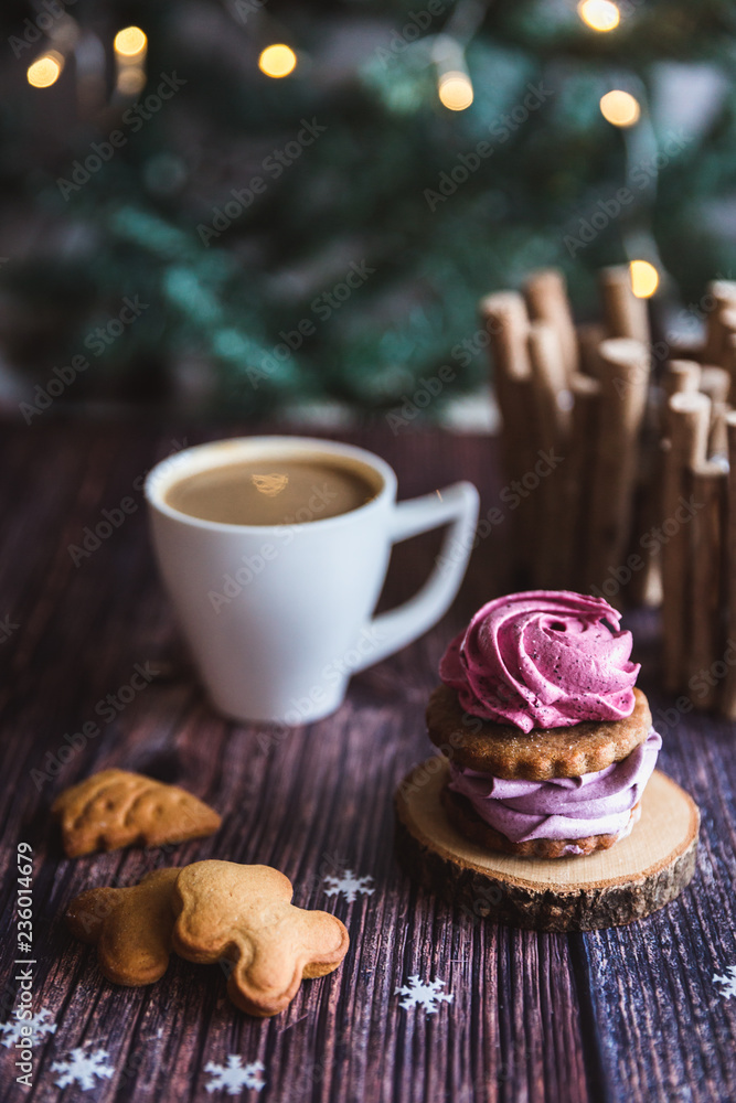 Close up of homemade pink and purple zephyr or marshmallow in powdered sugar with white mug on wooden with abstract bokeh background. Black currant, blueberry marshmallows. Close up of homemade pink and purple zephyr or marshmallow in powdered sugar with white mug on wooden with abstract bokeh background. Black currant, blueberry marshmallows.