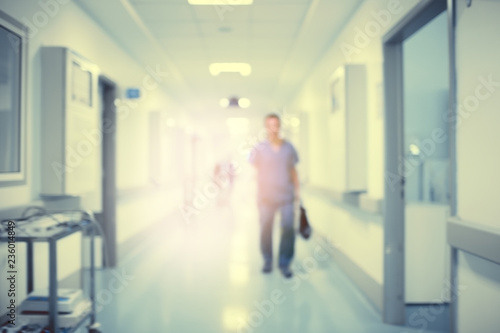 Hospital hallway with the silhouette of a medical doctor in the rays of a mysterious light  defocused background.