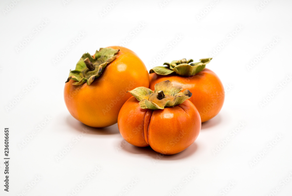 three ripe orange persimmons isolated on white three ripe orange persimmons isolated on white