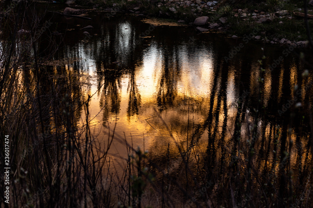 Reflections of the sunset in the water of the river. Reflections of the sunset in the water of the river.