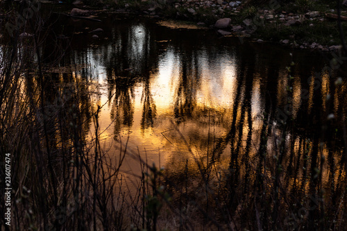 Reflections of the sunset in the water of the river.