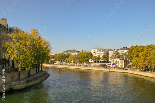 View from the Pont of Sully of the banks of the Seine River with people and autumn trees