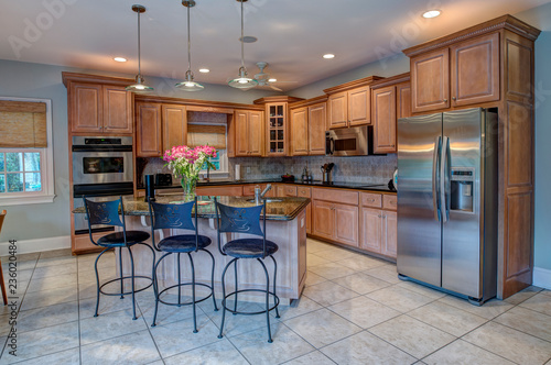 Beautiful kitchen with island and stainless steel appliances. photo