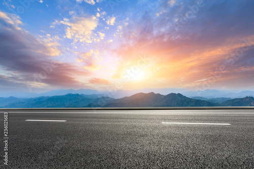 Asphalt road and mountains at beautiful sunset © ABCDstock