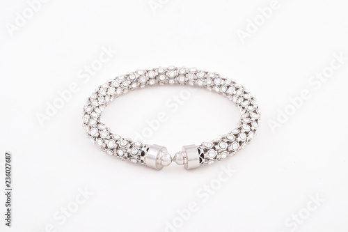 Simple stylish silver or platinum diamond bracelet or bangle on white background.
