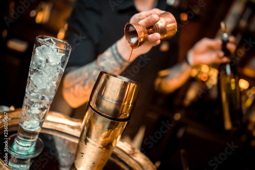 whiskey poured into a glass with ice using a steel dispenser