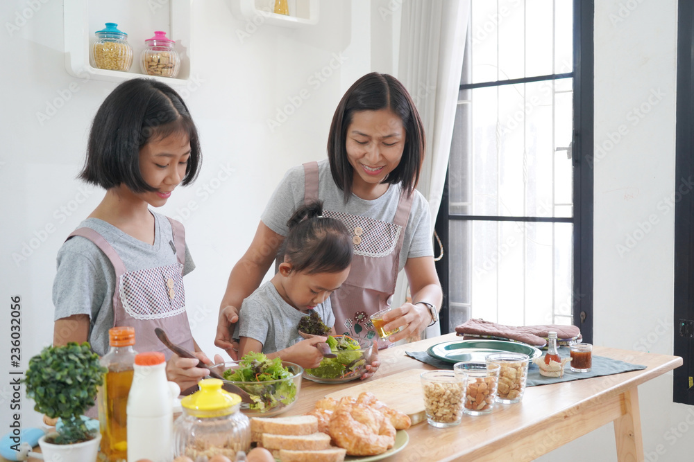 Mother and daughter cooking in the kitchen at home, happy family asian concept