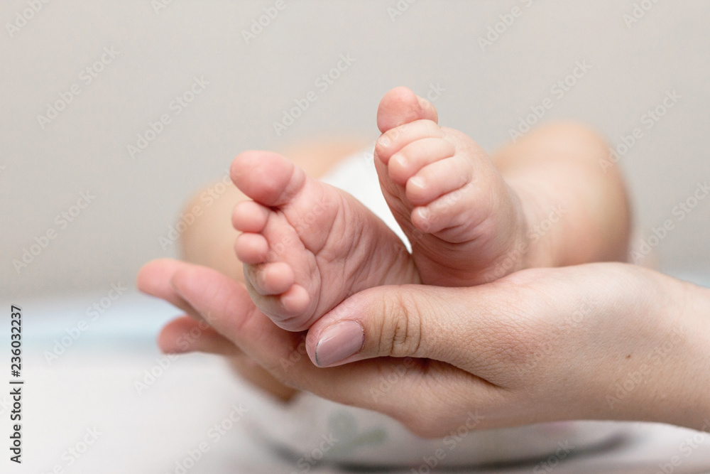 Mother is giving a massage to her newborn son Mother is giving a massage to her newborn son