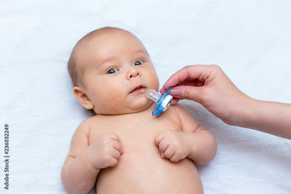 mother giving a pacifier to her newborn son mother giving a pacifier to her newborn son