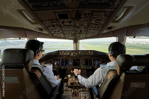 Foto Two airliner pilots are flying the airplane towards the runway