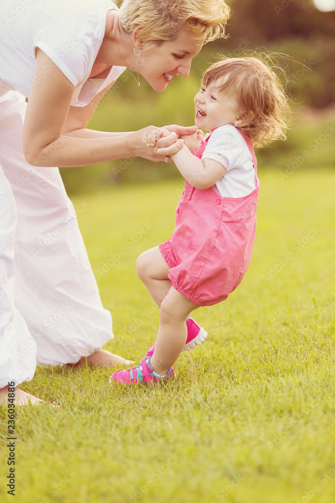 Fototapeta premium mother and little daughter playing at backyard