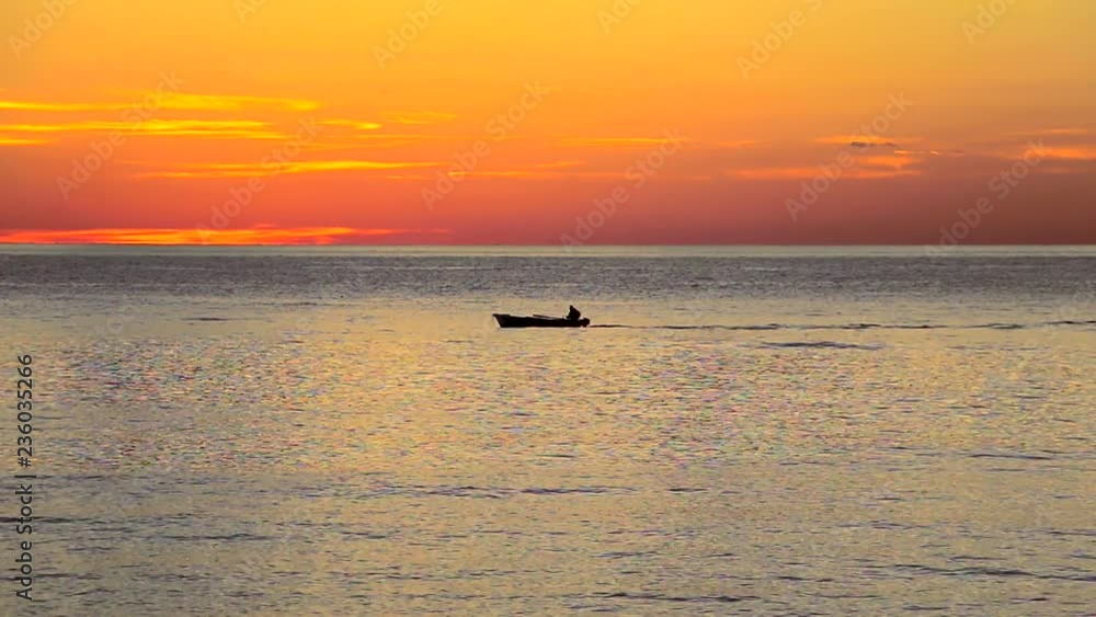 Fishermen on the sea. Fishermens drive the boat and go to the fishing at sunset Fishermen on the sea. Fishermens drive the boat and go to the fishing at sunset