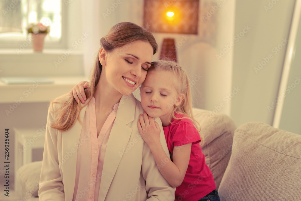 Pleasant peaceful mother and daughter closing their eyes Pleasant peaceful mother and daughter closing their eyes