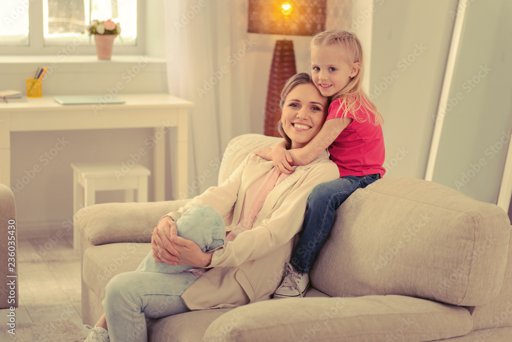 Cute happy young girl embracing her mother