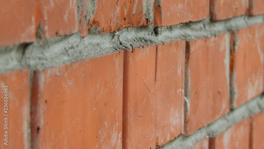 Red stone brick wall with concrete joints