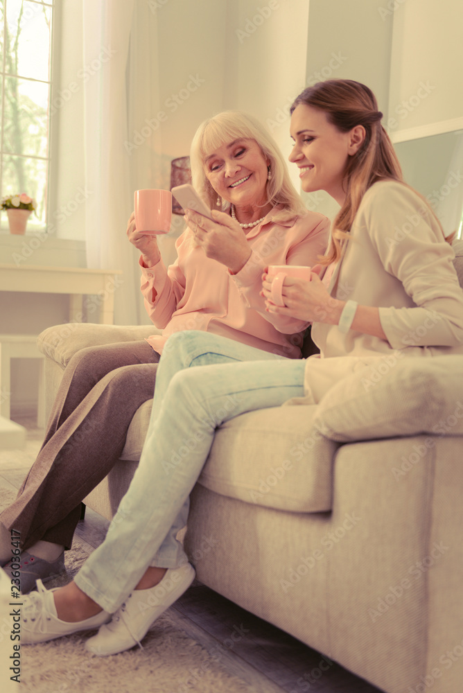 Positive aged woman holding her new smartphone