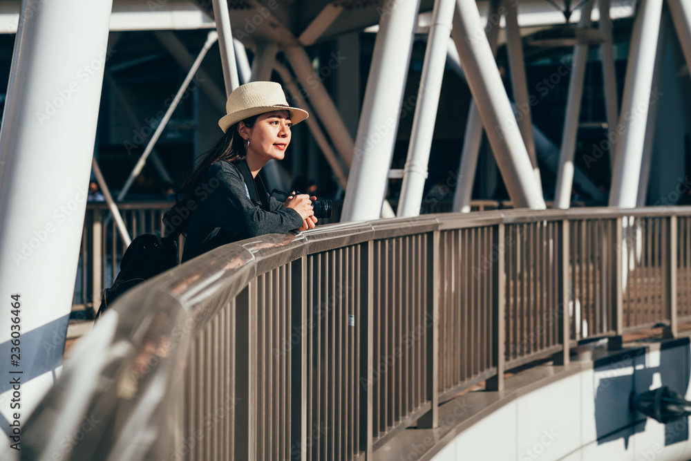 Naklejka premium girl traveler relying on handrail sightseeing