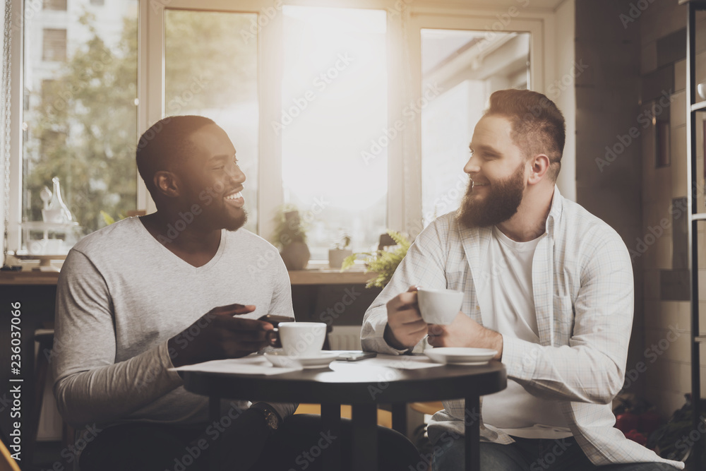 Multiethnic company of men communicates in a cafe Multiethnic company of men communicates in a cafe