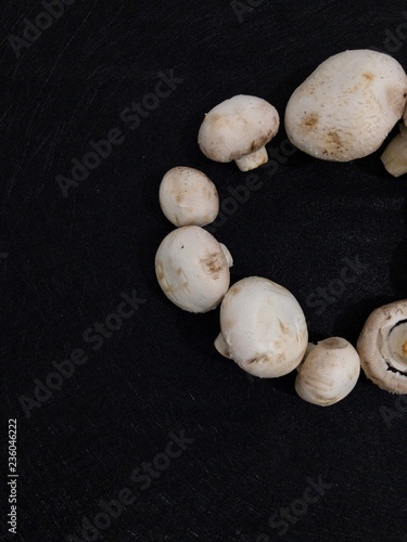 Creative Top view flat lay of fresh raw mushrooms on black background with copy space