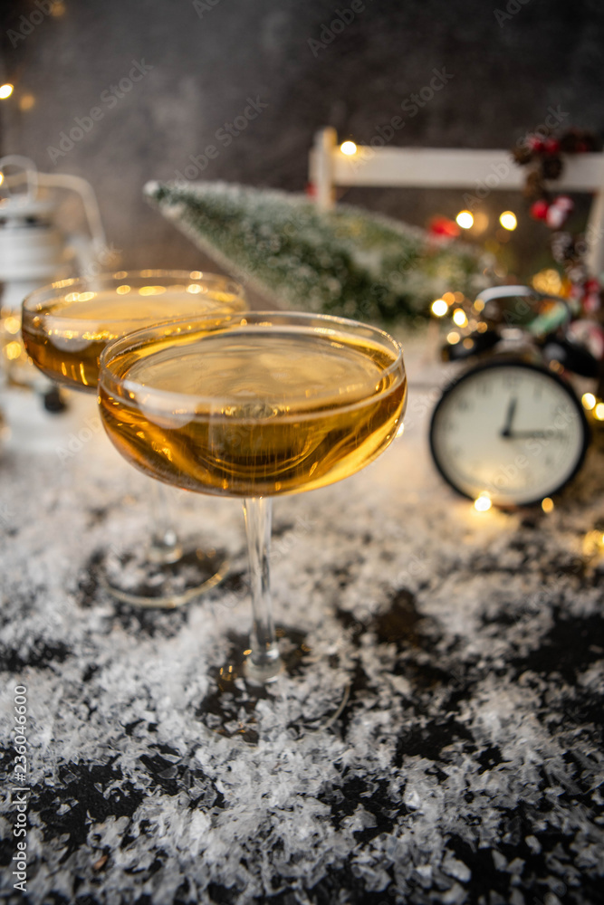 Picture of two wine glasses on blurred background with Christmas tree, lantern, clock Picture of two wine glasses on blurred background with Christmas tree, lantern, clock