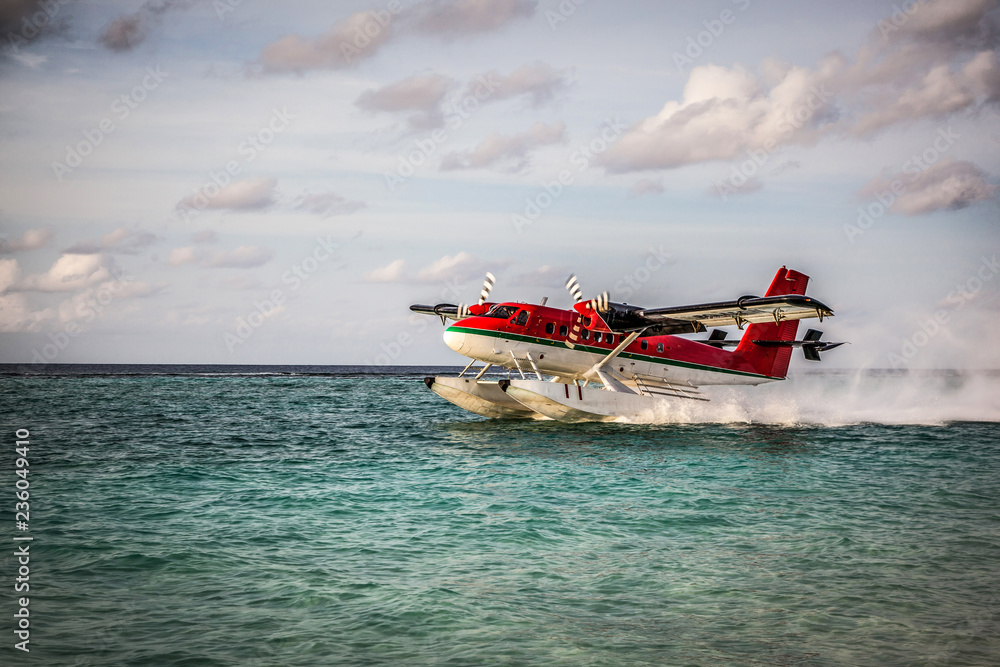 Seaplane landing in the ocean lagoon. The takeoff of a seaplane from the ocean beach. Seaplane landing in the ocean lagoon. The takeoff of a seaplane from the ocean beach.