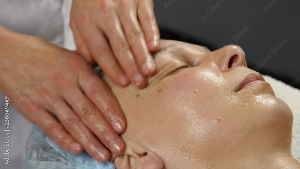 female doctor doing anti-aging massage to client. woman enjoys plastic face massage in spa saton. 4K female doctor doing anti-aging massage to client. woman enjoys plastic face massage in spa saton. 4K