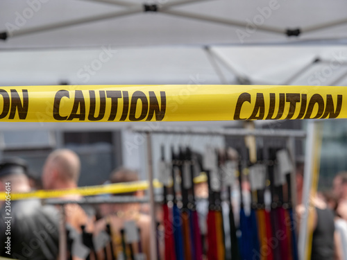 Yellow caution tape hanging in front of BDSM store with whips