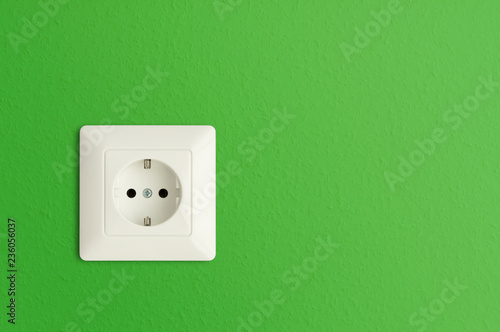 electrical power socket on green wall, green electric power outlet, European standard