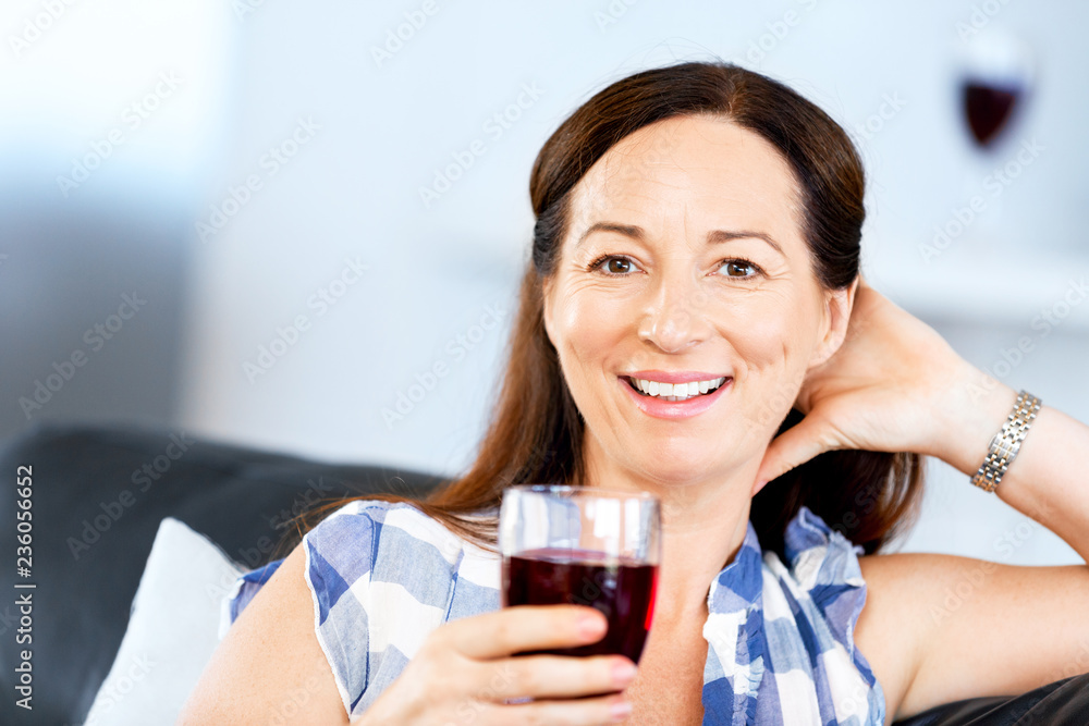 Woman with holding a glass of wine indoors Woman with holding a glass of wine indoors