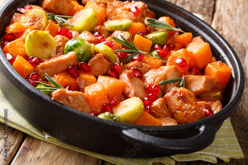 Organic food chicken pieces with vegetables and rosemary in pomegranate sauce close-up in a frying pan. horizontal