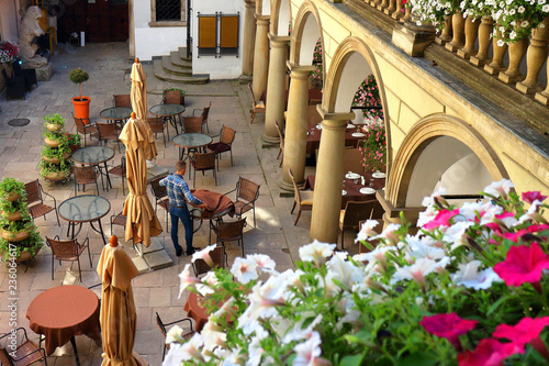 View on chairs and tables in cafe of Italian courtyard loggia arcade of the Korniakt palace (kamienica Krуlewska) on old town in the center of Lvov photo