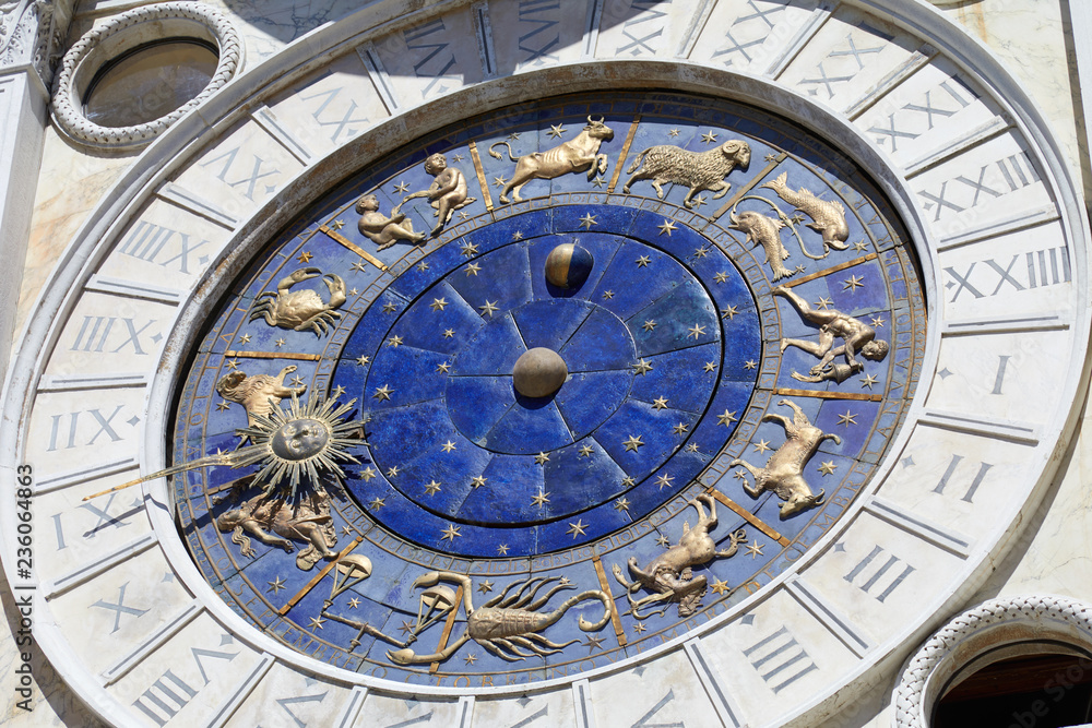 Astrological clock with gold zodiac signs in a sunny day