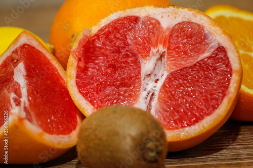 Various raw citrus fruit on wooden table. Close-up of lemon, orange, grapefruit and kiwi.